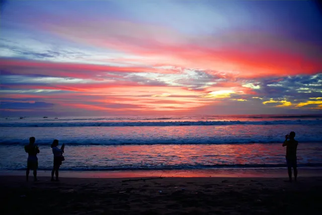 surfers enjoying sunset waves at kuta beach bali with a vibrant sky 1
